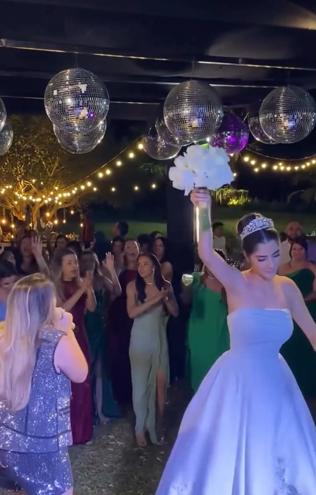 Noiva erguendo o buquê durante a apresentação